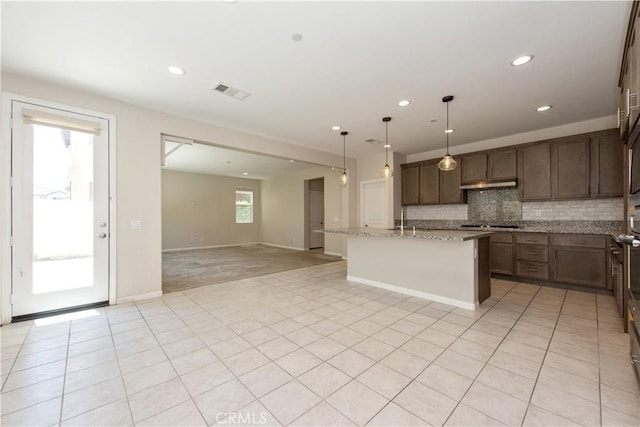 16123 Apricot Ave, Chino, CA 91708 - kitchen featuring open floor plan, tasteful backsplash, light stone countertops, a center island with sink, and recessed lighting