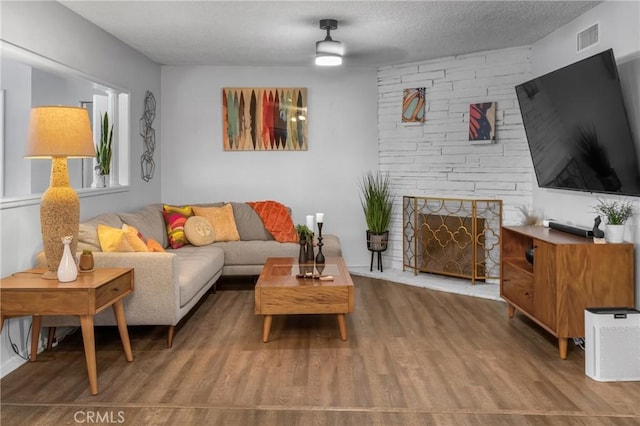 9811 Kempster Ave, Fontana, CA 92335 - living area with wood finished floors, a fireplace, and a textured ceiling