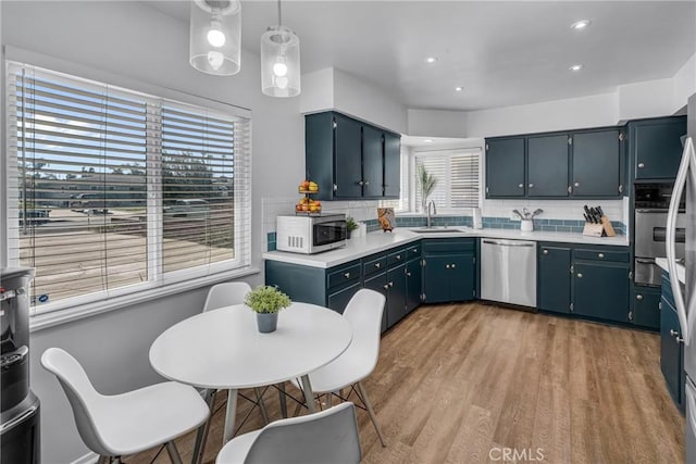 9811 Kempster Ave, Fontana, CA 92335 - kitchen featuring stainless steel appliances, light countertops, decorative backsplash, light wood-style floors, and recessed lighting