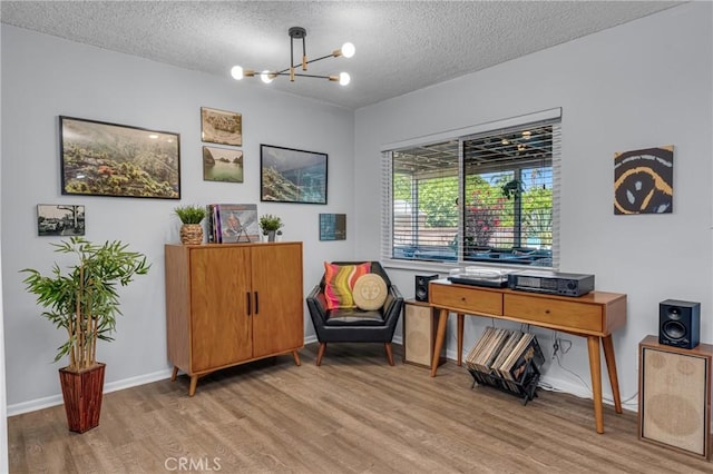 9811 Kempster Ave, Fontana, CA 92335 - sitting room with wood finished floors, a chandelier, and a textured ceiling