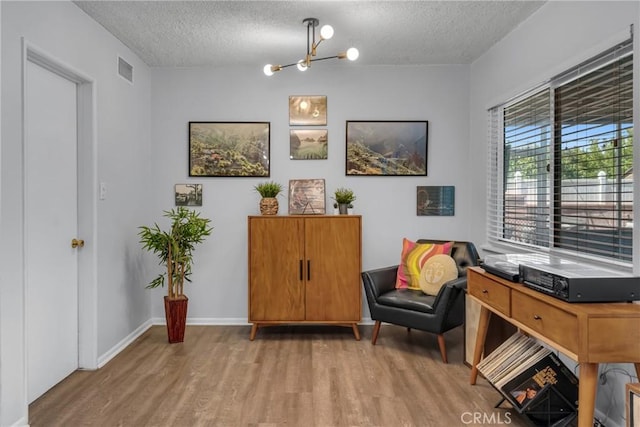 9811 Kempster Ave, Fontana, CA 92335 - sitting room featuring wood finished floors, a textured ceiling, and a chandelier