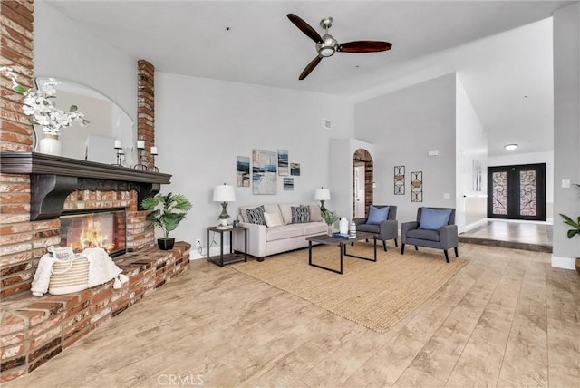 5560 Feather Grass Ln, Yorba Linda, CA 92887 - living area featuring arched walkways, a ceiling fan, a fireplace, lofted ceiling, and wood finished floors