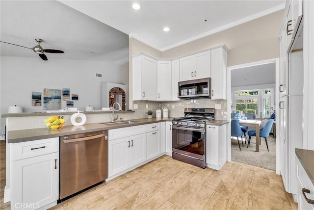 5560 Feather Grass Ln, Yorba Linda, CA 92887 - kitchen featuring appliances with stainless steel finishes, a peninsula, dark countertops, backsplash, and white cabinets