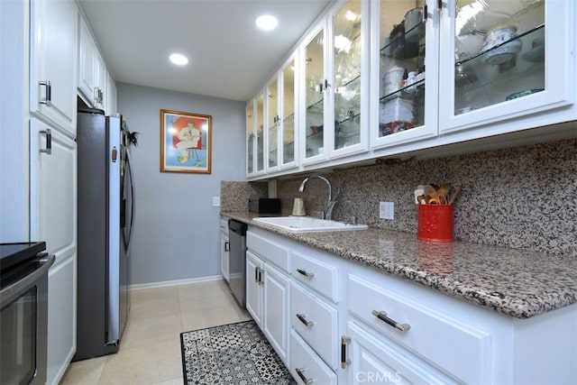 4140 Warner Blvd Unit 302, Burbank, CA 91505 - kitchen featuring appliances with stainless steel finishes, decorative backsplash, white cabinets, glass insert cabinets, and recessed lighting