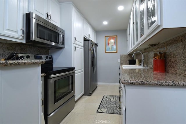 4140 Warner Blvd Unit 302, Burbank, CA 91505 - kitchen featuring appliances with stainless steel finishes, tasteful backsplash, white cabinets, light tile patterned floors, and recessed lighting