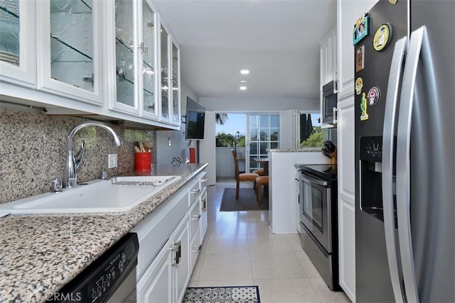 4140 Warner Blvd Unit 302, Burbank, CA 91505 - kitchen featuring appliances with stainless steel finishes, decorative backsplash, white cabinets, recessed lighting, and glass insert cabinets