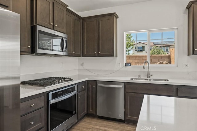 26627 Pearl Blossom Way, Menifee, CA 92585 - kitchen featuring appliances with stainless steel finishes, dark brown cabinets, light wood-type flooring, and light countertops