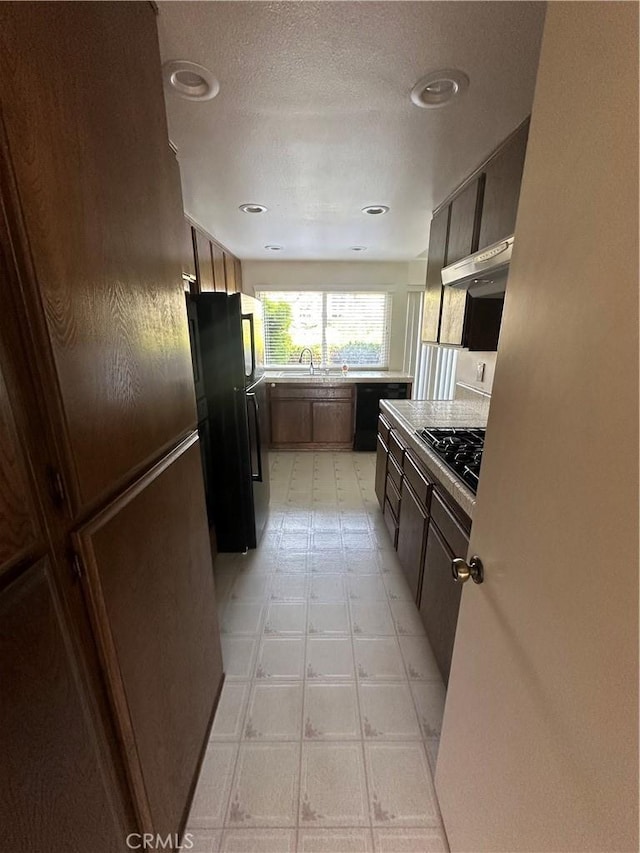 15 Hilltop Cir, Rancho Palos Verdes, CA 90275 - kitchen with range hood, black appliances, light floors, light countertops, and dark brown cabinets