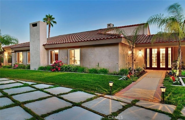 940 N Silent Ranch Dr, Glendora, CA 91741 - back of house with french doors, a chimney, a lawn, a tiled roof, and stucco siding