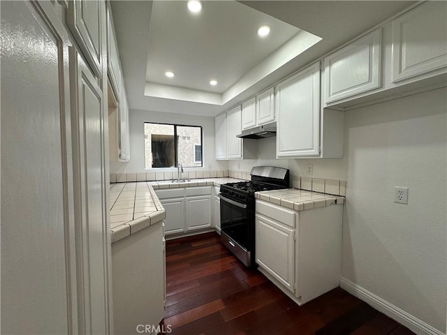 1024 S Marengo Ave Unit 6, Alhambra, CA 91803 - kitchen with stainless steel range with gas stovetop, tile counters, under cabinet range hood, dark wood-style floors, and white cabinetry