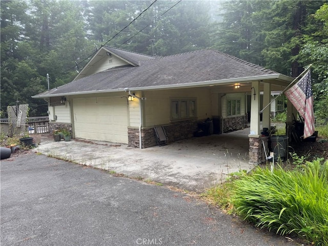 5595 Cummings Rd, Eureka, CA 95503 - view of property exterior with stone siding, roof with shingles, asphalt driveway, and a view of trees