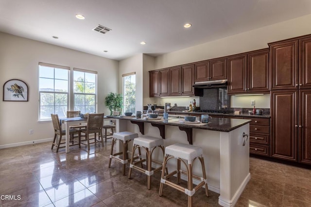 219 Via Rebecca, Thousand Oaks, CA 91320 - kitchen featuring under cabinet range hood, a kitchen breakfast bar, stainless steel gas cooktop, a center island with sink, and recessed lighting