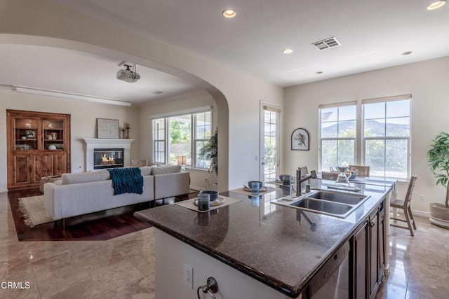 219 Via Rebecca, Thousand Oaks, CA 91320 - kitchen with arched walkways, recessed lighting, dark stone countertops, dishwashing machine, and a center island with sink