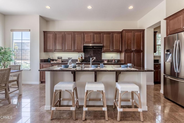 219 Via Rebecca, Thousand Oaks, CA 91320 - kitchen featuring stainless steel fridge, under cabinet range hood, dark stone countertops, a breakfast bar area, and recessed lighting