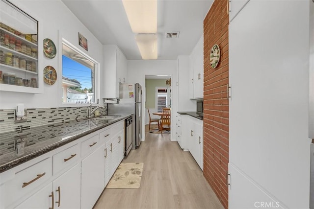 1011 Portola Dr, Arcadia, CA 91007 - kitchen with light wood finished floors, white cabinetry, backsplash, and stainless steel dishwasher