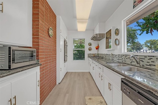 1011 Portola Dr, Arcadia, CA 91007 - kitchen featuring stainless steel appliances, light wood-type flooring, white cabinets, brick wall, and dark stone counters