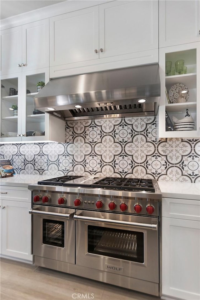 2526 N La Colina Ct, Orange, CA 92867 - kitchen with range with two ovens, wall chimney exhaust hood, light countertops, white cabinets, and decorative backsplash