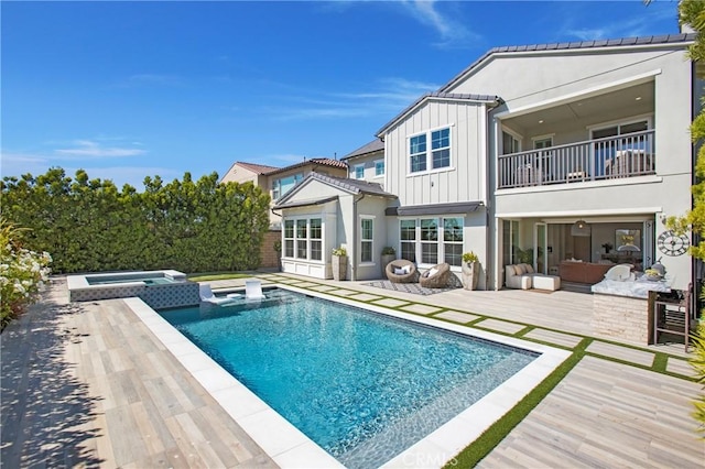 2526 N La Colina Ct, Orange, CA 92867 - rear view of property featuring a balcony, board and batten siding, a pool with connected hot tub, outdoor lounge area, and a wooden deck