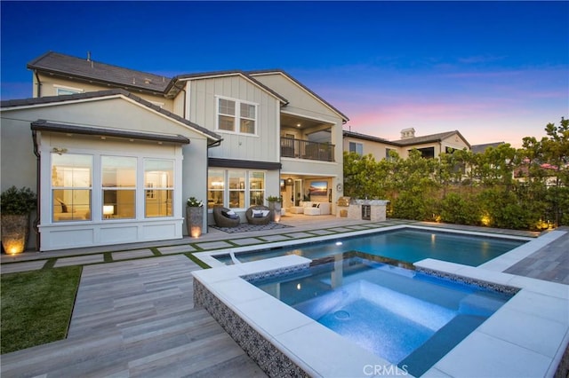 2526 N La Colina Ct, Orange, CA 92867 - back of house at dusk with a balcony, an outdoor hangout area, a pool with connected hot tub, and a patio area