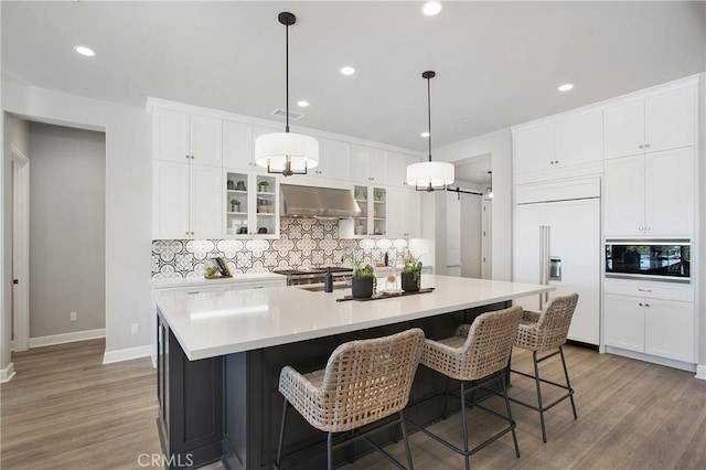 2526 N La Colina Ct, Orange, CA 92867 - kitchen with built in appliances, ventilation hood, backsplash, light wood-style flooring, and recessed lighting