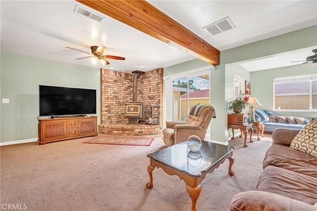 929 9th St, Williams, CA 95987 - living room with a ceiling fan, a wood stove, healthy amount of natural light, carpet flooring, and beam ceiling