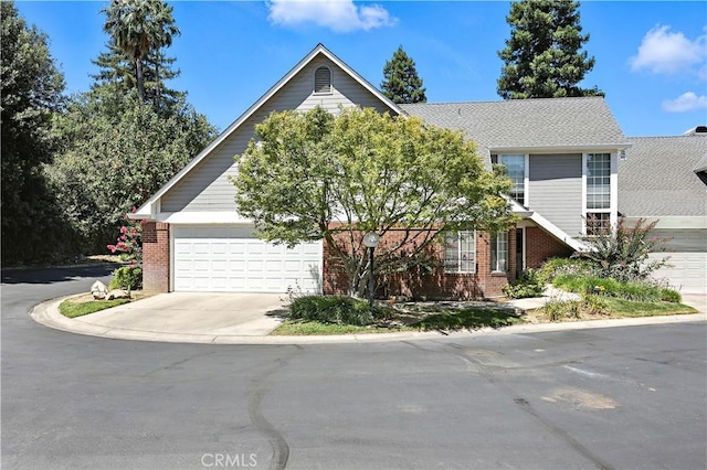 524 St Kevin Ct, Merced, CA 95348 - view of property hidden behind natural elements featuring brick siding, concrete driveway, and an attached garage