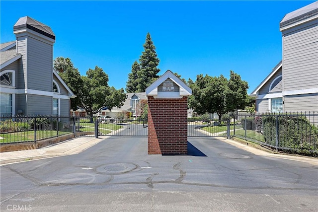 524 St Kevin Ct, Merced, CA 95348 - view of asphalt road featuring a gate, a gated entry, and curbs