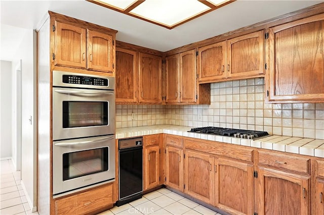 524 St Kevin Ct, Merced, CA 95348 - kitchen featuring appliances with stainless steel finishes, light tile patterned flooring, backsplash, and tile counters