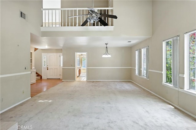 524 St Kevin Ct, Merced, CA 95348 - unfurnished living room featuring a high ceiling, carpet flooring, a ceiling fan, and stairs