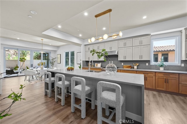 620 Baldwin Ct, Sierra Madre, CA 91024 - kitchen with a breakfast bar area, recessed lighting, tasteful backsplash, light wood finished floors, and under cabinet range hood