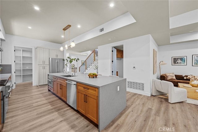 620 Baldwin Ct, Sierra Madre, CA 91024 - kitchen featuring stainless steel appliances, open floor plan, light wood-type flooring, a kitchen island with sink, and light countertops