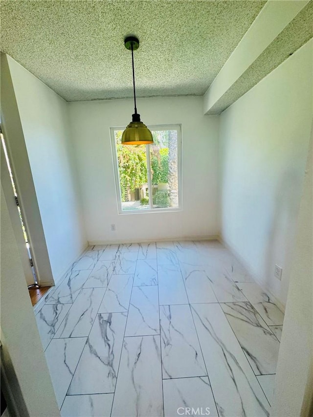 5484 Dobbs St Unit 132, Los Angeles, CA 90032 - unfurnished dining area with marble look tiles and a textured ceiling