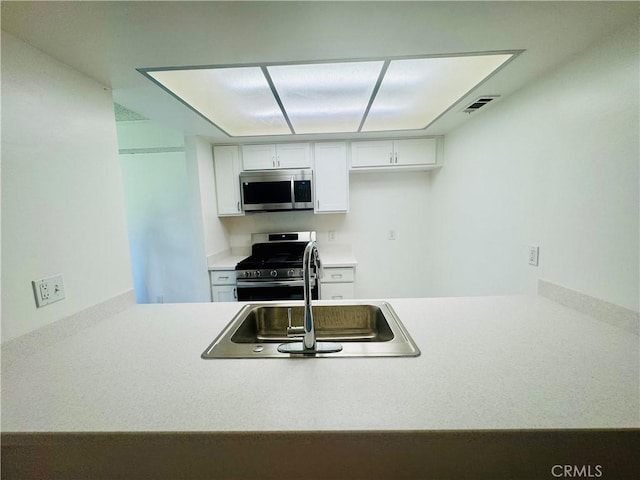 5484 Dobbs St Unit 132, Los Angeles, CA 90032 - kitchen with stainless steel appliances, white cabinets, light countertops, and a peninsula