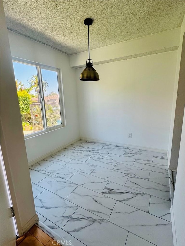 5484 Dobbs St Unit 132, Los Angeles, CA 90032 - unfurnished dining area with marble look tile flooring and a textured ceiling