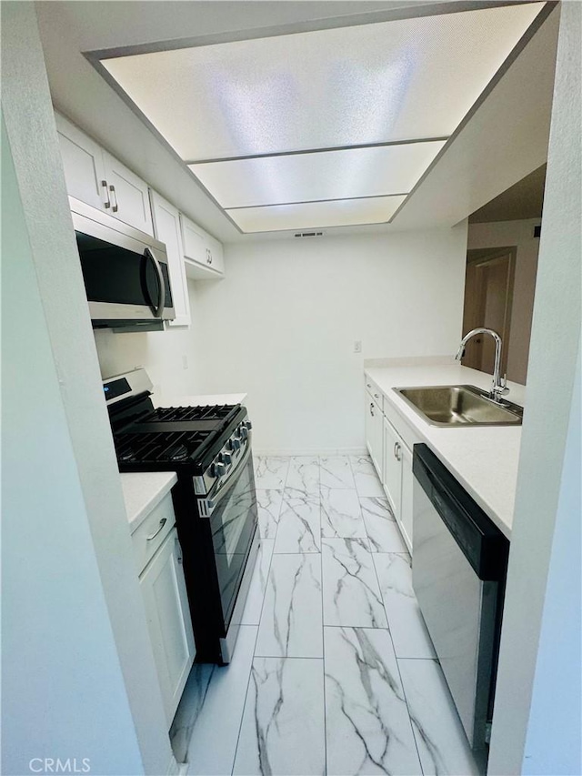 5484 Dobbs St Unit 132, Los Angeles, CA 90032 - kitchen with appliances with stainless steel finishes, light marble finish flooring, light countertops, and white cabinets