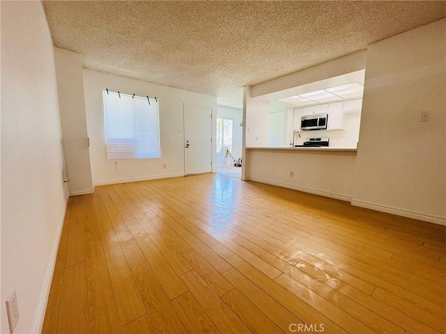 5484 Dobbs St Unit 132, Los Angeles, CA 90032 - unfurnished living room featuring light wood-style floors and a textured ceiling