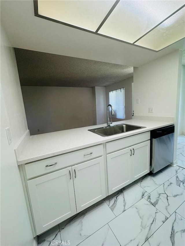 5484 Dobbs St Unit 132, Los Angeles, CA 90032 - kitchen featuring stainless steel dishwasher, a peninsula, white cabinets, light marble finish flooring, and light countertops