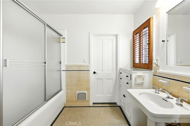 408 N Mccadden Pl, Los Angeles, CA 90004 - full bath featuring tile walls, bath / shower combo with glass door, wainscoting, and tile patterned flooring