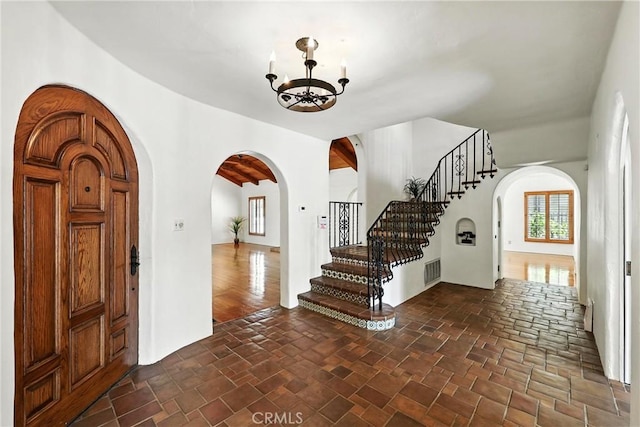 408 N Mccadden Pl, Los Angeles, CA 90004 - entryway with arched walkways, a chandelier, stairway, and dark stone finish flooring