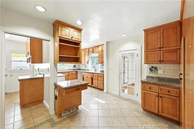 408 N Mccadden Pl, Los Angeles, CA 90004 - kitchen with light tile patterned floors, tasteful backsplash, open shelves, dark stone countertops, and recessed lighting