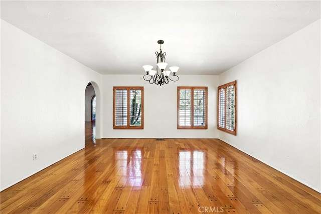 408 N Mccadden Pl, Los Angeles, CA 90004 - spare room featuring arched walkways, light wood finished floors, and a chandelier