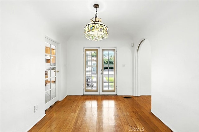 408 N Mccadden Pl, Los Angeles, CA 90004 - unfurnished dining area with wood-type flooring, french doors, and a chandelier