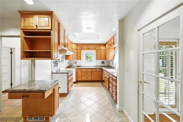 408 N Mccadden Pl, Los Angeles, CA 90004 - kitchen with a skylight, inlaid floor details, under cabinet range hood, light tile patterned flooring, and tasteful backsplash