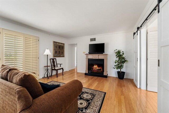 5231 Hiram Ln, Irvine, CA 92603 - living area with a barn door, light wood-style flooring, a lit fireplace, and crown molding