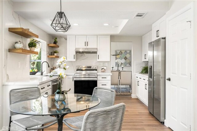 19 Jefferson, Irvine, CA 92620 - kitchen with stainless steel appliances, under cabinet range hood, light countertops, open shelves, and backsplash