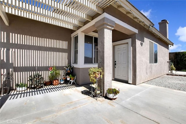 8103 David Way, Jurupa Valley, CA 92509 - doorway to property featuring a patio area, stucco siding, and a chimney