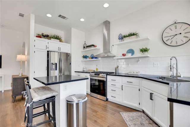 8103 David Way, Jurupa Valley, CA 92509 - kitchen with appliances with stainless steel finishes, wall chimney range hood, open shelves, dark countertops, and white cabinets