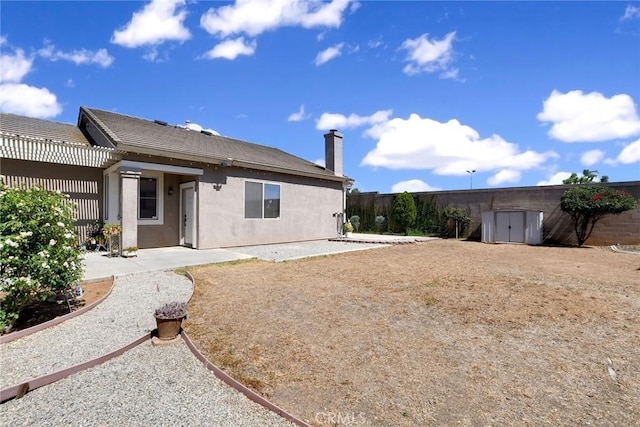 8103 David Way, Jurupa Valley, CA 92509 - rear view of house featuring a storage unit, a patio, a fenced backyard, and a chimney