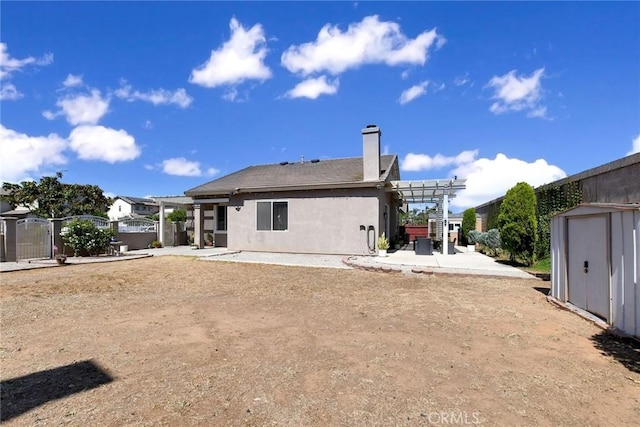 8103 David Way, Jurupa Valley, CA 92509 - back of house with a patio area, a shed, a chimney, stucco siding, and a pergola