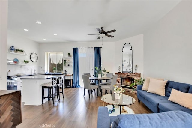 8103 David Way, Jurupa Valley, CA 92509 - living area featuring a ceiling fan, wood finished floors, a brick fireplace, and recessed lighting